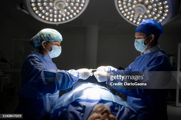 doctors in surgery in the operating room - cirugía stock pictures, royalty-free photos & images