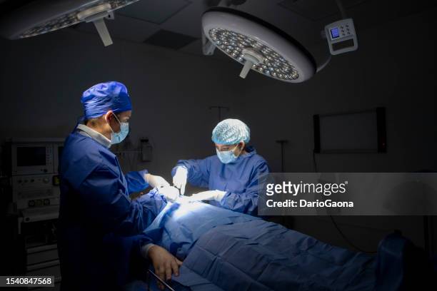 doctors in surgery in the operating room - artículo médico stockfoto's en -beelden