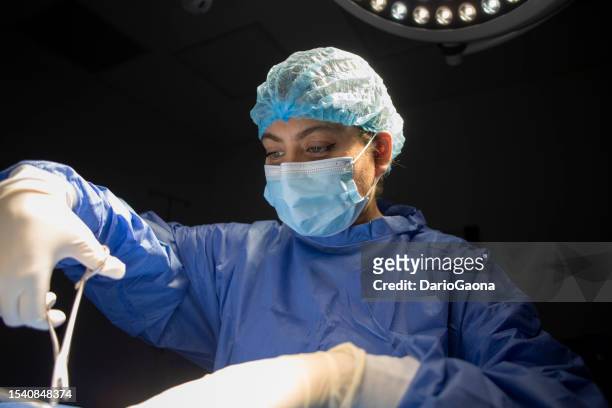 doctors in surgery in the operating room - adulto joven 個照片及圖片檔