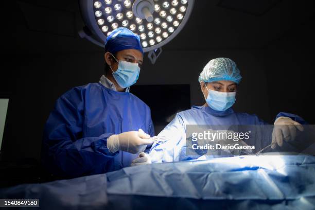 doctors in surgery in the operating room - artículo médico stockfoto's en -beelden