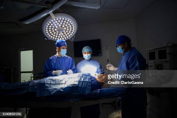 doctors in surgery in the operating room - doctora stockfoto's en -beelden