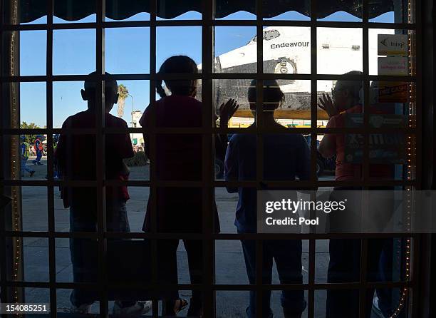 Children watch as the Space Shuttle Endeavour passes on Crenshaw Blvd. Enroute to the California Science Center during its final journey on October...