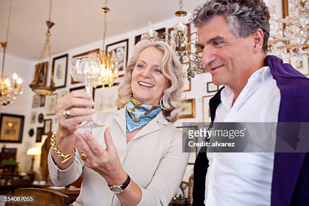 adult couple shopping in an antique shop - antique shop stockfoto's en -beelden
