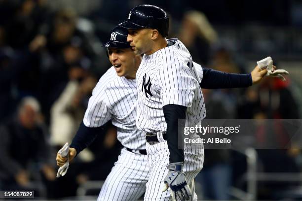 Mark Teixeira and Raul Ibanez of the New York Yankees celebrate after they both scored on a 2-run home run hit by Ibanez in the bottom of the ninth...