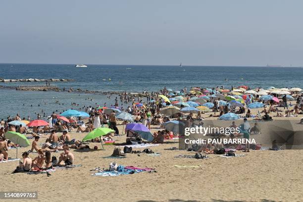 Beach-goers enjoy Barceloneta's beach in Barcelona on July 18, 2023. Spain issued hot weather red alerts for three regions due to the "extreme"...