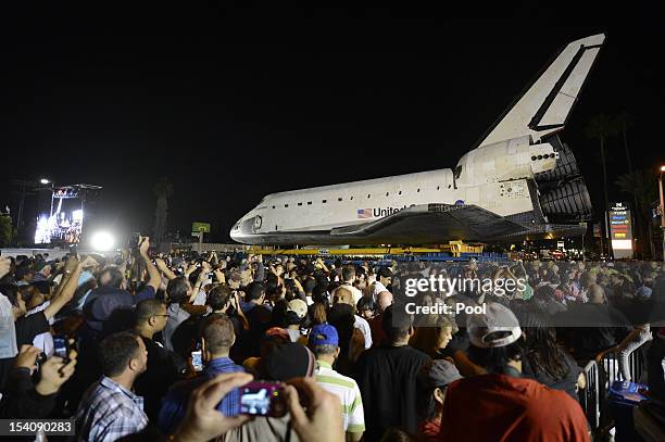 Spectators gather around the Space Shuttle Endeavour as it stops outside the Baldwin Hill Crenshaw Mall on October 13, 2012 in Baldwin Hills,...