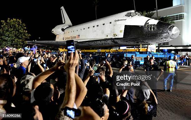 Spectators takes pictures of the shuttle Endeavour as it moves along Crenshaw Blvd. On October 13, 2012 in Inglewood, California. Endeavour is on its...