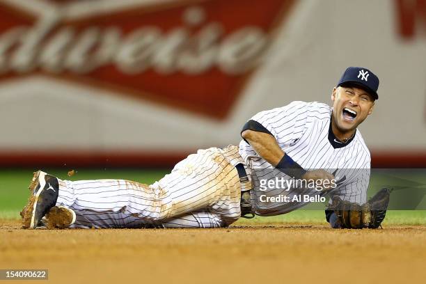 Derek Jeter of the New York Yankees reacts after he injured his leg in the top of the 12th inning against the Detroit Tigers during Game One of the...