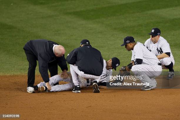 Derek Jeter of the New York Yankees is tended to by trainer Steve Donohue , manager Joe Girardi , Robinson Cano and Brett Gardner of the New York...