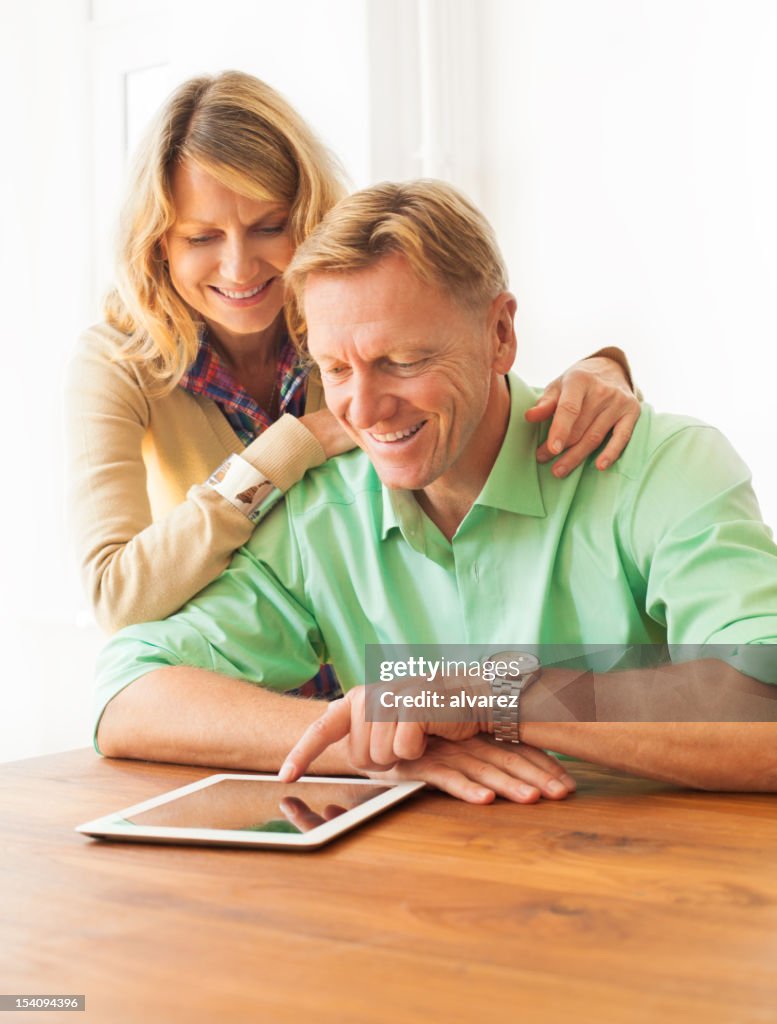 Mature adult couple playing with a digital tablet