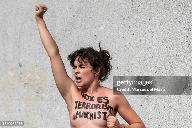 An activist of feminist group FEMEN with her bare chest painted with messages against gender-based murder of women protesting in front of the far...