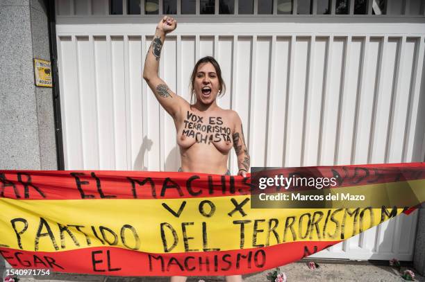 An activist of feminist group FEMEN with her bare chest painted with messages against gender-based murder of women are seen protesting in front of...