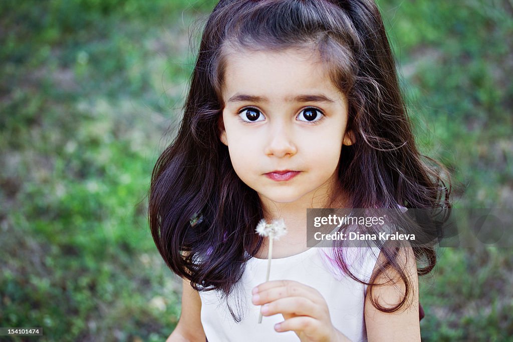 Portrait of beautiful girl with dandelion