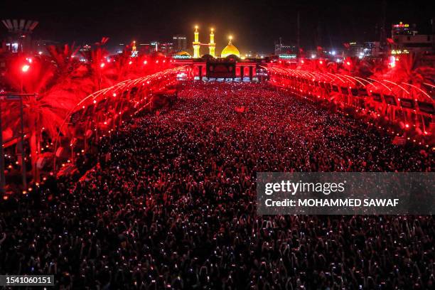 Shiite Muslim devotees gather during the flag-changing ceremony at the shrines of Imam Hussein and Imam Abbas in Iraq's central shrine city of...