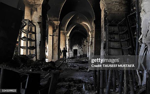 Syrian rebel walks inside a burnt section of the Umayyad Mosque in the old city of Aleppo hours before the Syrian army retook control of the complex...