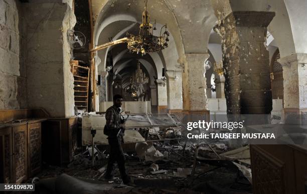 Syrian rebel walks inside the damaged Umayyad Mosque in the old city of Aleppo hours before the Syrian army retook control of the complex on October...