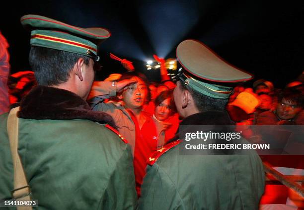 Fan mocks PLA officers with a salute during the Snow Mountain Festival in Lijiang, 18 August 2002. This mountainside town in southwestern Yunnan...