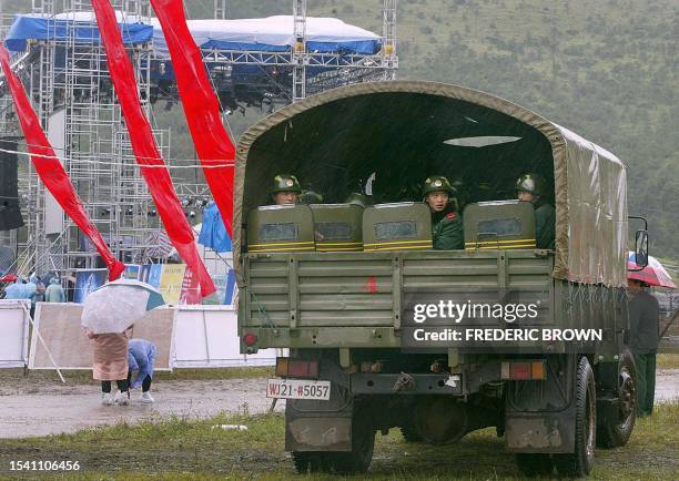 Truckload of People's Liberation Army soldiers with riot-gear wait in their vehicle, 17 August 2002, near the stage for the Snow Mountain Music...