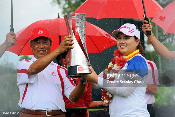 Inbee Park of South Korea receives the Sime Darby LPGA Trophy from the Deputy Prime Minister of Malaysia Tan Sri Muhyiddin Yassin under the rain...
