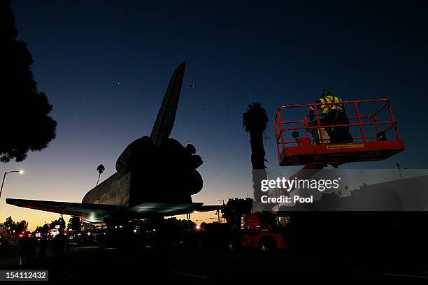 The sun rises as the Space Shuttle Endeavour slowly moves along Martin Luther King Boulevard to the California Science Center on October 14, 2012 in...