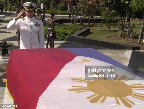 Pacific Armed Forces commander Admiral Thomas Fargo salutes the Philippine flag draped over the tomb of the unknown soldier at a military cemetery in...