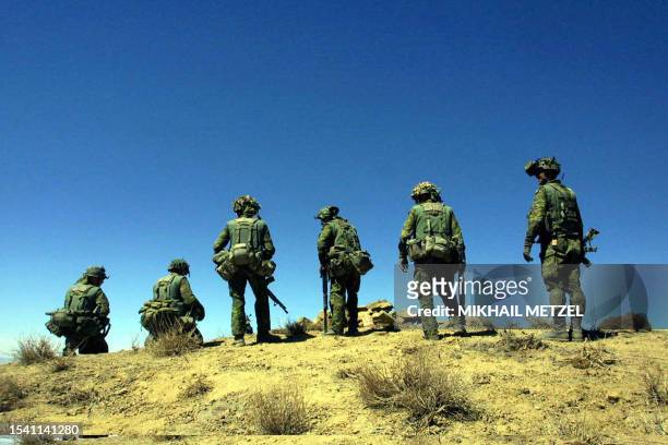 Soldiers from Princess Patricia's Canadian Light Infantry battalion look down the hill during a combat mission in the rugged Shahi Kot mountains on...