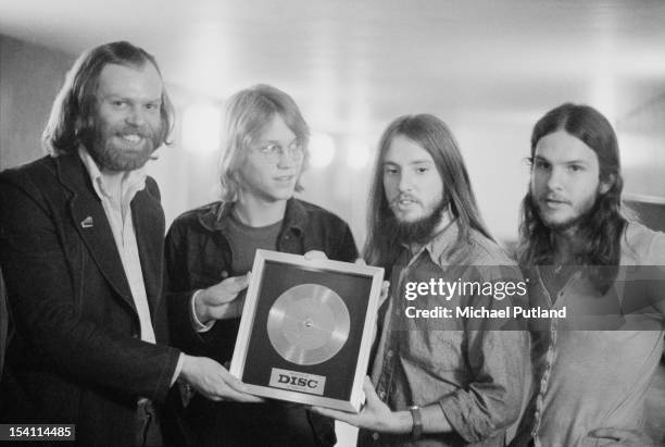 British music presenter Bob Harris presents an award from the music magazine Disc And Music Echo to Anglo-American folk rock band America, at the...