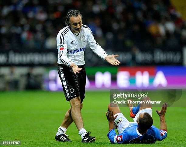 Maurizio Gaudino of Germany goes to assist Angelo di Livio of Italy during the century match between Germany and Italy at Commerzbank Arena on...