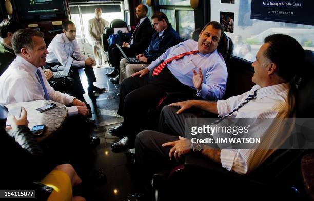 Republican presidential candidate Mitt Romney and New Jersey Governor Chris Christie speak with Romney's advisor Bob White onboard the campaign bus...