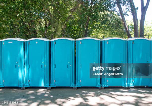 a row of portable toilets in a city mall. - baños públicos fotografías e imágenes de stock