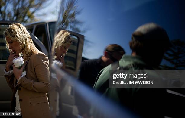Press wrangler Lyndsay Keith talks on the phone next to the Romney motorcade while waiting outside the Double Tree Hotel in Miamisburg, Ohio, October...