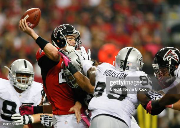 Matt Ryan of the Atlanta Falcons throws an interception as he is hit by Philip Wheeler of the Oakland Raiders at Georgia Dome on October 14, 2012 in...