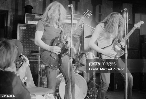 Cameraman filming guitarists Rick Parfitt and Francis Rossi during a performance with English rock group Status Quo at the Marquee Club, London, 21st...