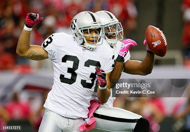 Michael Huff of the Oakland Raiders celebrates with Tyvon Branch after Huff's intercetion against the Atlanta Falcons at Georgia Dome on October 14,...