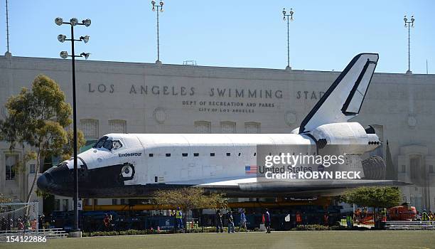 The Space Shuttle Endeavour passes the Los Angeles Swimming Stadium as it arrives at the end of its journey to the California Science Center in...