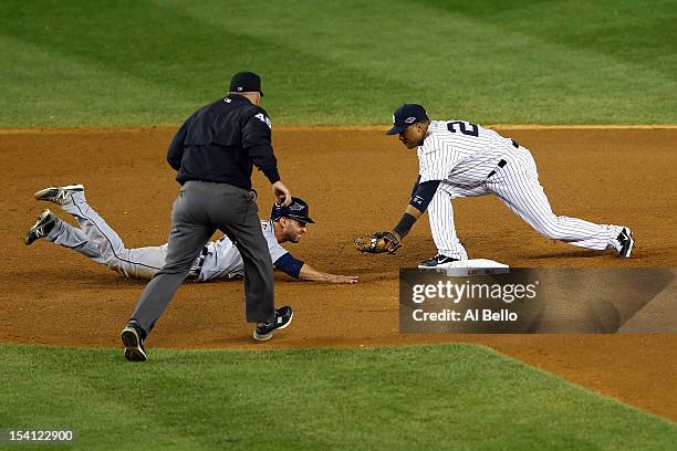 Umpire Jeff Nelson calls Omar Infante of the Detroit Tigers safe as he dove back into second base against Robinson Cano of the New York Yankees in...