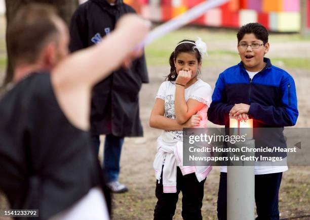 Jamie Lummus of Conroe, left, and her friend Jahir Cavazos watch the Luminosity Fire Throwers spinning group demonstrate their talents Tuesday, Dec....