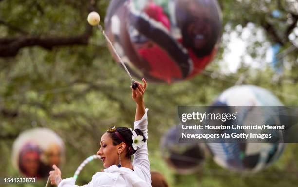 Angel Ajmani of the Luminosity Fire Throwers spinning group twirls a pair of Polynesian Poi Balls as she and her Fire-mates do a demonstration to...