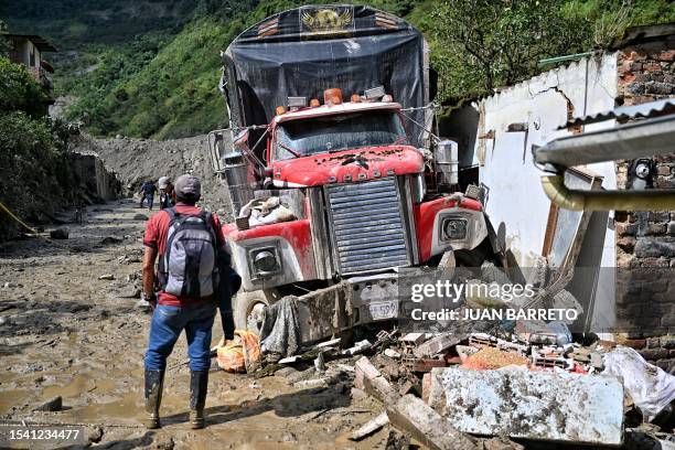 Man observes a destroyed truck after a landslide in the Quetame municipality, Cundinamarca department, Colombia, on July 18, 2023. Rescue teams with...