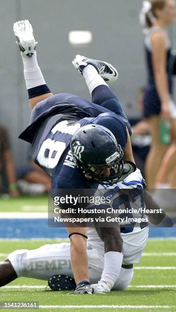 Rice University running back Turner Petersen uses his arm to stay on his feet as Memphis University linebacker Sam Cage tries to tackle him in the...