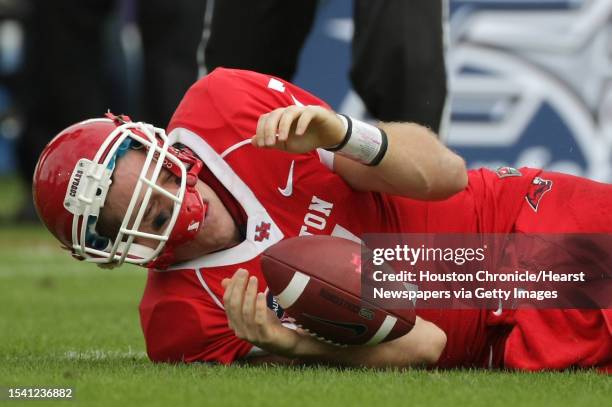 University of Houston quarterback Case Keenum rolls to his side after being sacked during the second quarter of the 2011 Conference USA Football...