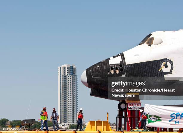 Transport crews secure the Space Shuttle replica, which will be named at Space Center Houston, at it's docking station, Friday, June 1 in Houston....