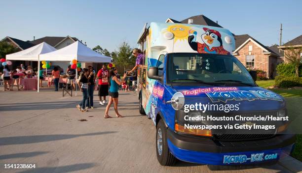 Tiffany Spiegal, owner and operator of the Kona Ice truck, visits a block party where she serves shaved snow cones, Wednesday, May 30 in Cypress....