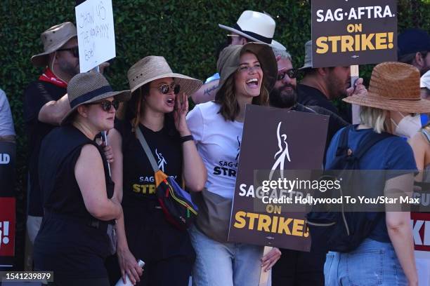 Katie Lowes and Mandy Moore walk the picket line in support of the SAG-AFTRA and WGA strike on July 18, 2023 in Los Angeles, California.