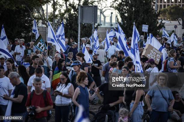 Demonstrators march with national flags during a 'day of resistance' to protest the Israeli government's judicial overhaul bill, near the Supreme...