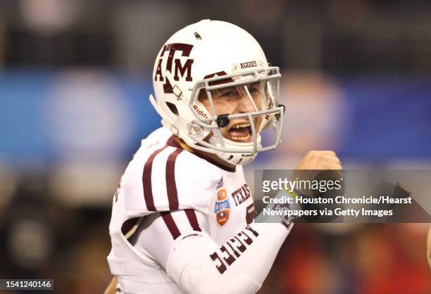 Texas A&M quarterback Johnny Manziel celebrates his 23-yard touchdown over the Oklahoma defense during the first quarter of the Cotton Bowl college...