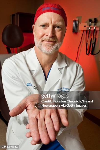 UPatrick Reardon M.D., shows the snapping mechanism on a a linx Reflux Management System, which helps relief symptoms of acid reflux, Thursday, May...