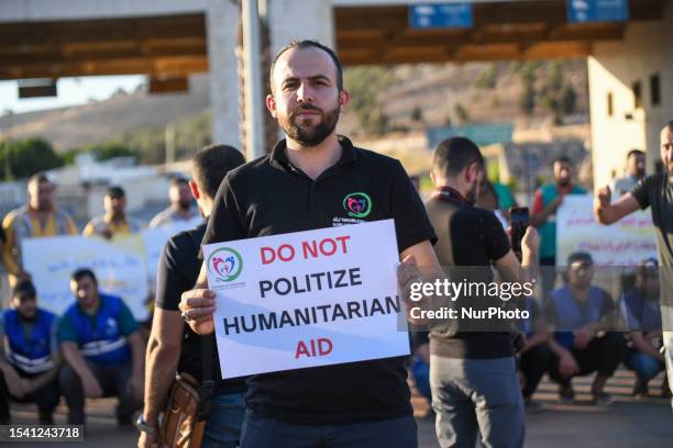 Humanitarian workers, activists, and journalists held banners in protest in front of the Bab al-Hawa border crossing with Turkey, opposing the...