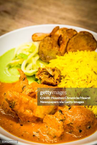 Pondicheri's butter chicken, rice, apple slaw, cilantro chutney, purple potato chips and mango pickle photographed Wednesday, July 26 in Houston.