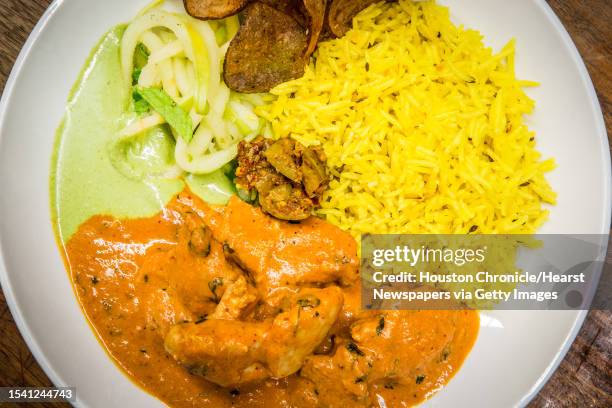 Pondicheri's butter chicken, rice, apple slaw, cilantro chutney, purple potato chips and mango pickle photographed Wednesday, July 26 in Houston.